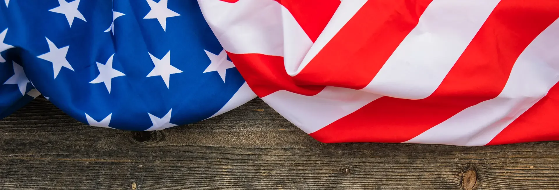 Close-up of an American flag draped over a wooden surface